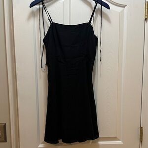 Black dress;  above the knee;  straps have ties for bows;  side zipper